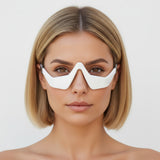 Woman wearing GloLift eyez led glasses against a plain background